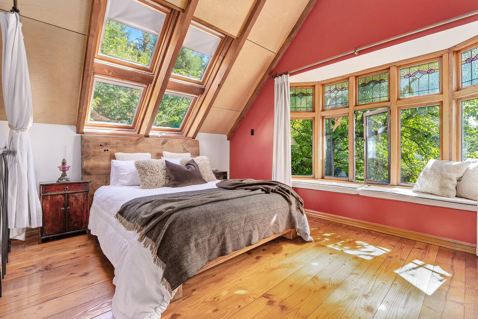 Decluttering · interior & exterior Styling · Property Staging Spacious attic bedroom with large dormer windows, white bedding, and sloped wooden ceilings